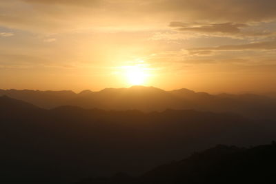 Scenic view of silhouette mountains against sky during sunset