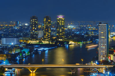 Illuminated buildings in city against sky at night