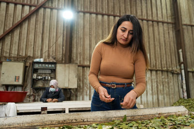 Portrait of young woman standing in factory