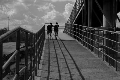 Rear view of people on staircase against sky