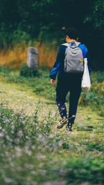 Rear view of woman walking on field