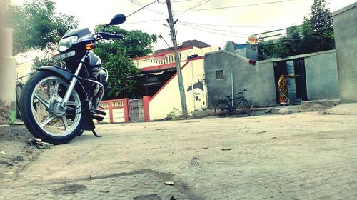 Bicycle parked on street against buildings in city