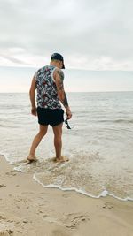 Full length rear view of woman walking on beach