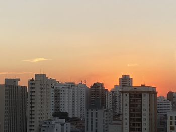 Buildings in city against sky during sunset