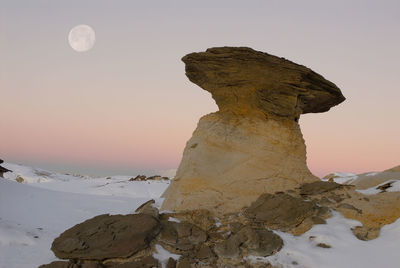 Low angle view of rock formation against clear sky during sunset