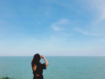 Rear view of woman looking at sea against sky