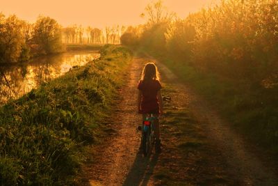 Rear view of girl on road against sky