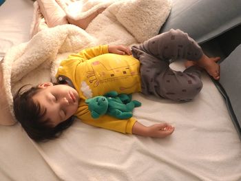 High angle view of baby girl sleeping on bed