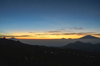 Scenic view of silhouette mountains against sky during sunset