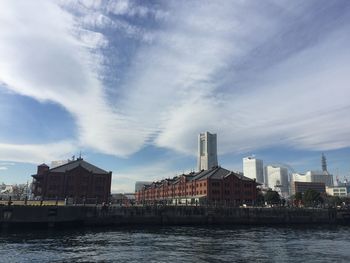 River amidst buildings in city against sky