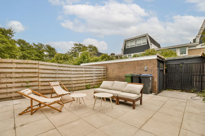 Empty chairs and tables in front of house