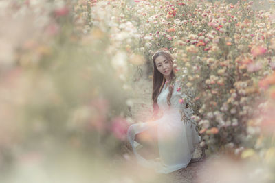 Woman standing by pink flowering tree