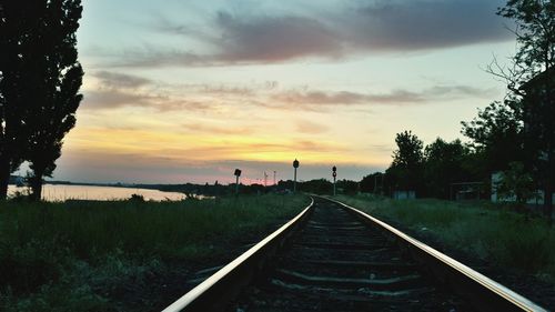 View of railroad tracks against sky during sunset