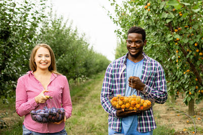 Portrait of a smiling young man standing in farm