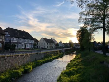 Canal amidst buildings against sky during sunset