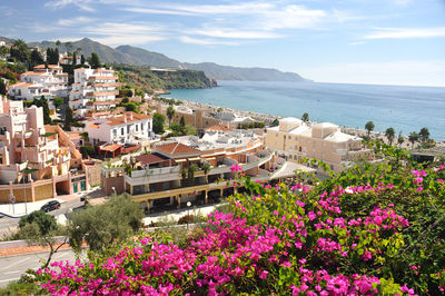 High angle view of townscape by sea against sky