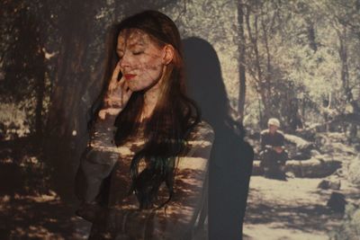 Close-up of young woman against trees