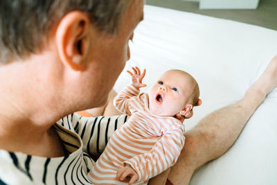 Cropped portrait of a newborn baby being held by her father