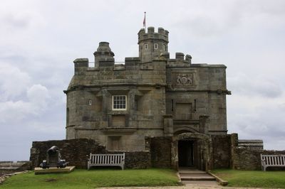 Low angle view of old building against cloudy sky