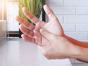 Midsection of woman touching wall