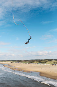 Woman enjoying bungee jumping at beach