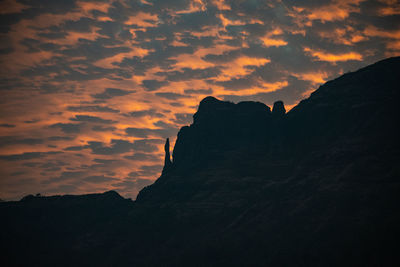 Low angle view of silhouette mountain against dramatic sky