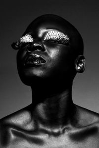 Close-up of shirtless female model with make-up against clear sky