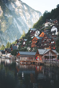 Houses by lake and buildings in city