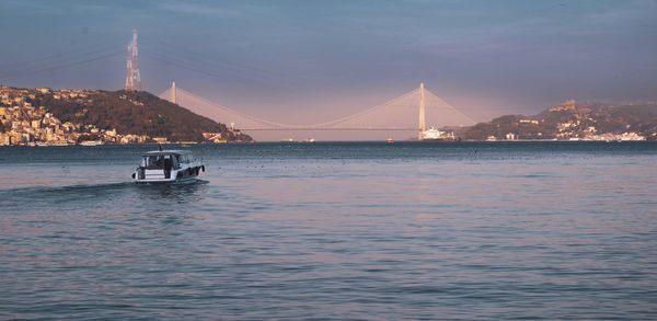 Illuminated bridge over river against sky at night