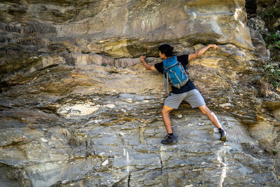 Rear view of man climbing on rock