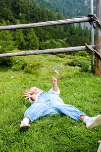 Side view of young woman lying on grass