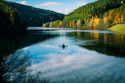 Scenic view of lake in forest against sky