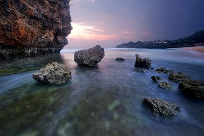 Rocks in sea against sky