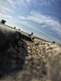 Surface level of road against cloudy sky