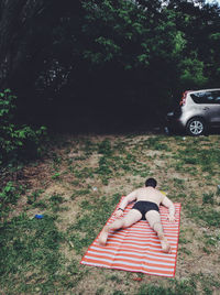 High angle view of shirtless man lying on mat