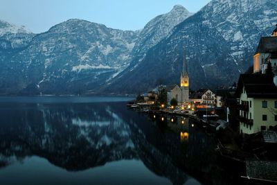 Scenic view of lake by snowcapped mountains against sky