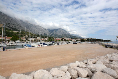 Pier at harbor in baska voda against cloudy sky