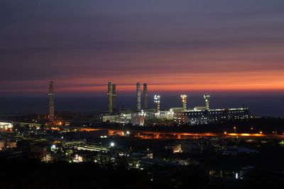 High angle view of illuminated factory against sky at night