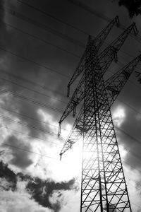 Low angle view of silhouette electricity pylon against sky