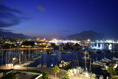 High angle view of illuminated harbor and buildings at night