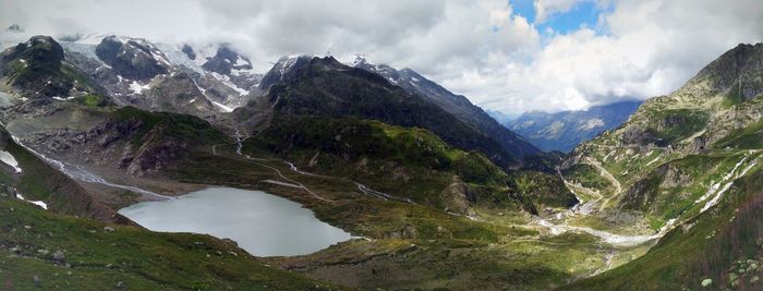 Scenic view of lake and mountains against cloudy sky