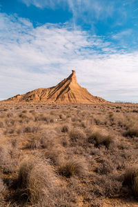 View of desert against cloudy sky