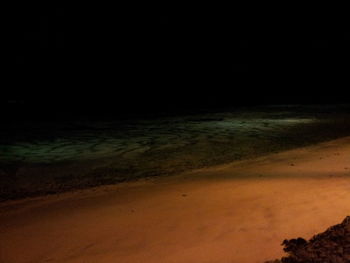 Scenic view of beach against sky at night