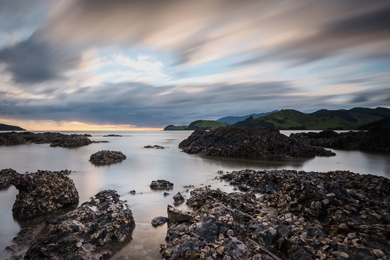 water, sky, tranquil scene, tranquility, scenics, cloud - sky, rock - object, beauty in nature, nature, beach, sea, shore, reflection, cloud, lake, idyllic, stone - object, mountain, cloudy, non-urban scene