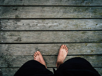 Low section of man standing on boardwalk