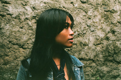 Close-up of woman looking away against rock