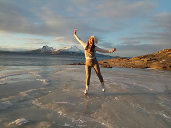 Full length of young woman standing in water