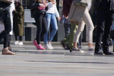 Low section of people walking on road