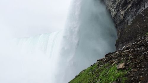 Scenic view of waterfall against sky