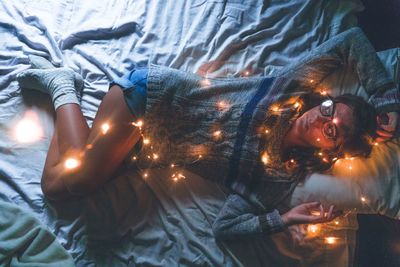 Close-up portrait of woman relaxing on bed at home